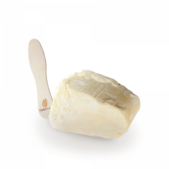 Un bloc de beurre de karité brut, bio, non raffiné, emballé dans du kraft avec une spatule en bois